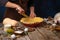 The chef puts the prepared dough into a baking dish. Cooking pumpkin pie. Lots of ingredients. Wooden texture. Country style.