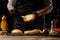 Chef puts sauce on a burger loaf, against the background of ingredients. Delicious and harmful food, fast food, homemade recipes,