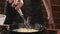 Chef puts spaghetti pasta in a frying pan with fried mushrooms, garlic and parsley in a restaurant kitchen. Food