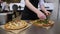 Chef putting arugula on pizza before serving in a traditional Italian pizzeria.