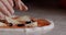 Chef putting ingredients on top of raw pizza, preparing for bake it.