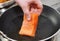 Chef putting salmon fillet on hot pan