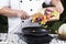 Chef putting vegetable to the pan