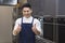 Chef raising his thumb up. Cheerful man stand at table in kitchen and look on camera. Man show thumb up