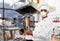 Chef in respirator with tablet pc at kebab shop