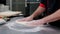 A chef in restaurant kitchen forming a dough for the pizza using a flour