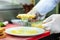 Chef in restaurant kitchen holding cheesy bread