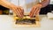 Chef rolling Maki Sushi with Rice, Shrimp Tempura, Avocado and Cheese inside covered Crispy Tempura Flour.