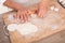 The chef rolls the dumpling wrapper on the cutting board with a rolling pin in hand