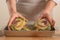 Chef rubs preparing to bake the artichoke on a light background, the concept of cooking tasty and healthy food, menu, recipe book