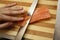 Chef`s hand cutting fish into thin slices with a knife