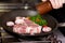 Chef\'s Hand Seasoning Meat In Pan