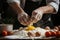 Chef\\\'s hands cracking an egg into a mound of flour, beginning preparation