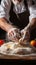 Chef\\\'s hands cracking an egg into a mound of flour, beginning preparation