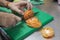 ChefÂ´s hands cutting pink tomato in slices using a sharp knife