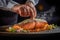 Chef\\\'s hands delicately sprinkling smoked sea salt and spices onto a salmon steak