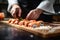 A chef\\\'s hands diligently prepare sushi rolls, an Asian culinary delight