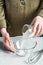 The chef`s hands pour sugar from a glass into a glass bowl