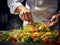 Chef\\\'s hands preparing a plate of salad in the kitchen