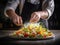 Chef\\\'s hands preparing a plate of salad in the kitchen