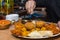 Chef\\\'s hands seasoning a tray of assorted Hindu appetizers