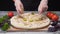Chef`s hands in silicone gloves taking a piece of pickles to his delicious fresh pizza. Frame. Italian food