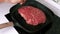 Chef salt a raw fresh steak on grill pan on white kitchen, marble meat