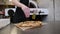 A chef salts baked pizza in the kitchen of a traditional Italian pizzeria.