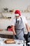 Chef in santa hat cooking a dessert in the kitchen making video for his vlog