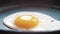 Chef seasons a frying egg, sunny side up, with ground pepper in a small frying pan over an industrial gas burning stove.