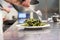 Chef serving fresh green bean salad from a bowl