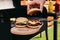 Chef serving hamburgers cooked outdoors on wooden board