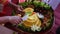 Chef serving nasi tumpeng (cone rice) served with urap-urap (Indonesian salad)