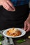 Chef serving pasta in white plate