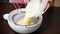 Chef sifting the dough in a bowl. To make a cake