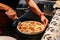 Chef slice a hot Caprese Bianca Pizza before serving. Ingredients are Mozzarella, Parmesan, Olive oil, sliced tomato and Dough