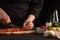 Chef slices cherry tomatoes closeup for cooking sauce. Seafood and oriental recipes