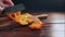 Chef slices an orange paprika on a cutting board in the kitchen on an old wooden table 