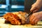 A chef slices roast meat.