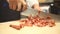 Chef slicing bacon in kitchen