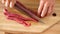 Chef slicing beef cutlet using sharp knife, close-up