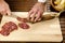Chef slicing salami, hands detail