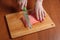 Chef slicing salmon fillet on wooden cutting board