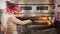 Chef with special shovel removing margherita pizza from stove