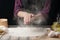 The chef sprinkles the flour on the surface. Black background