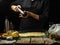 The chef sprinkles spices over the dough prepared for baking in the glass mold. Ingredients for making pizza, pie, focaccia.