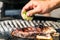 The chef squeezing lemon juice onto grilling steak