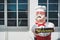 Chef. A statue of a fat chubby chef in white and red uniform holding welcome sign in front of restaurant dining room