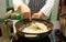 Chef is stirring risotto in large pan