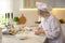 Chef with tablet cooking dough at table